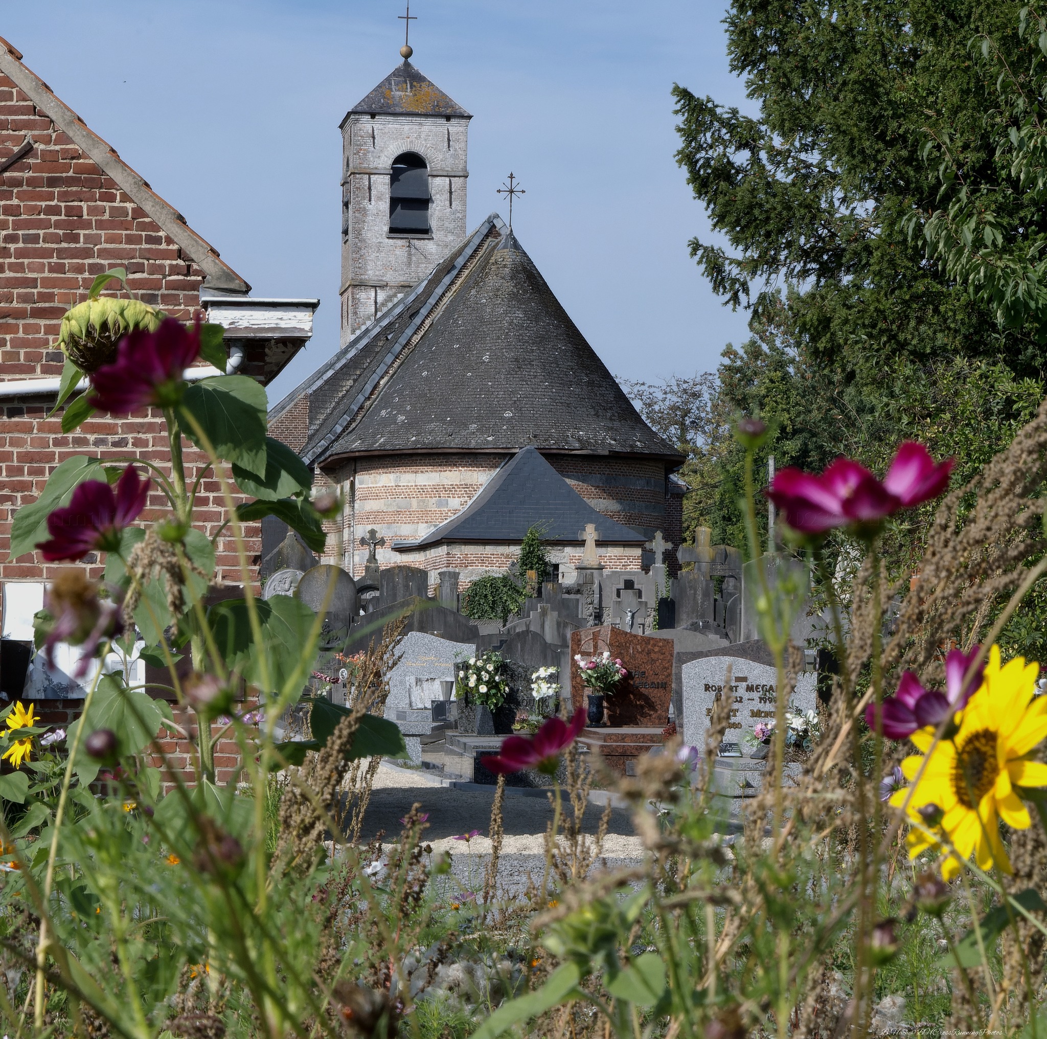 Arrière de l'église avec vue sur le cimetière fleuri.